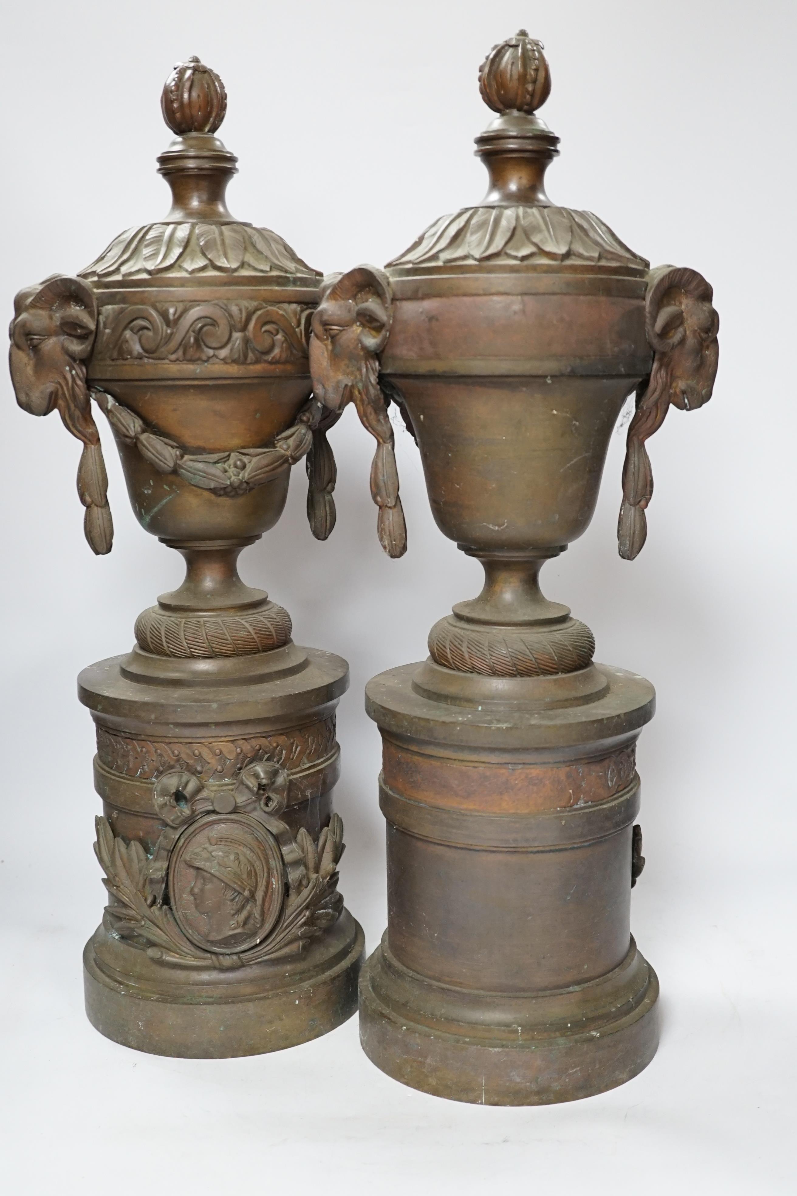 A pair of bronze urns with rams head, Roman mask and swag decoration, 53cm high